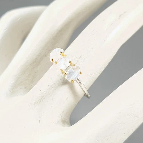 Silver ring with a clear gemstone on a white cushion
