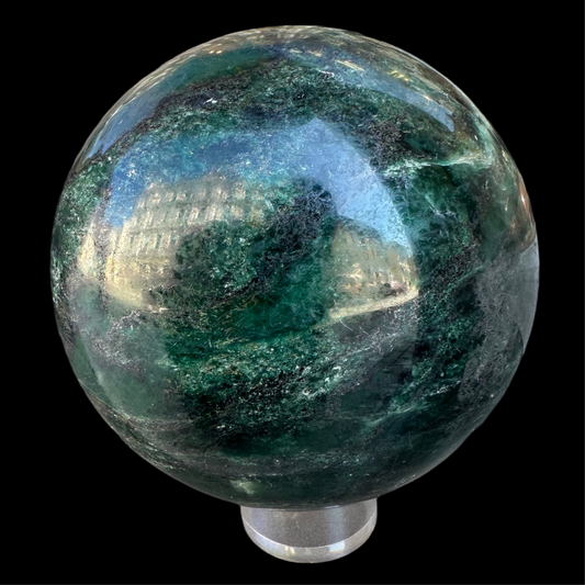 Aventurine Sphere 2400 kg 12 cm. Green crystal ball with a blurred building reflection on a black background
