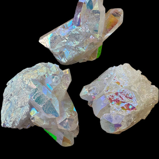quartz-crystal-65-75g Three iridescent crystal rocks on a black background