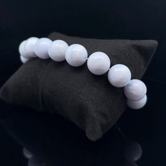 A bracelet with blue agate beads, displayed on a dark background.