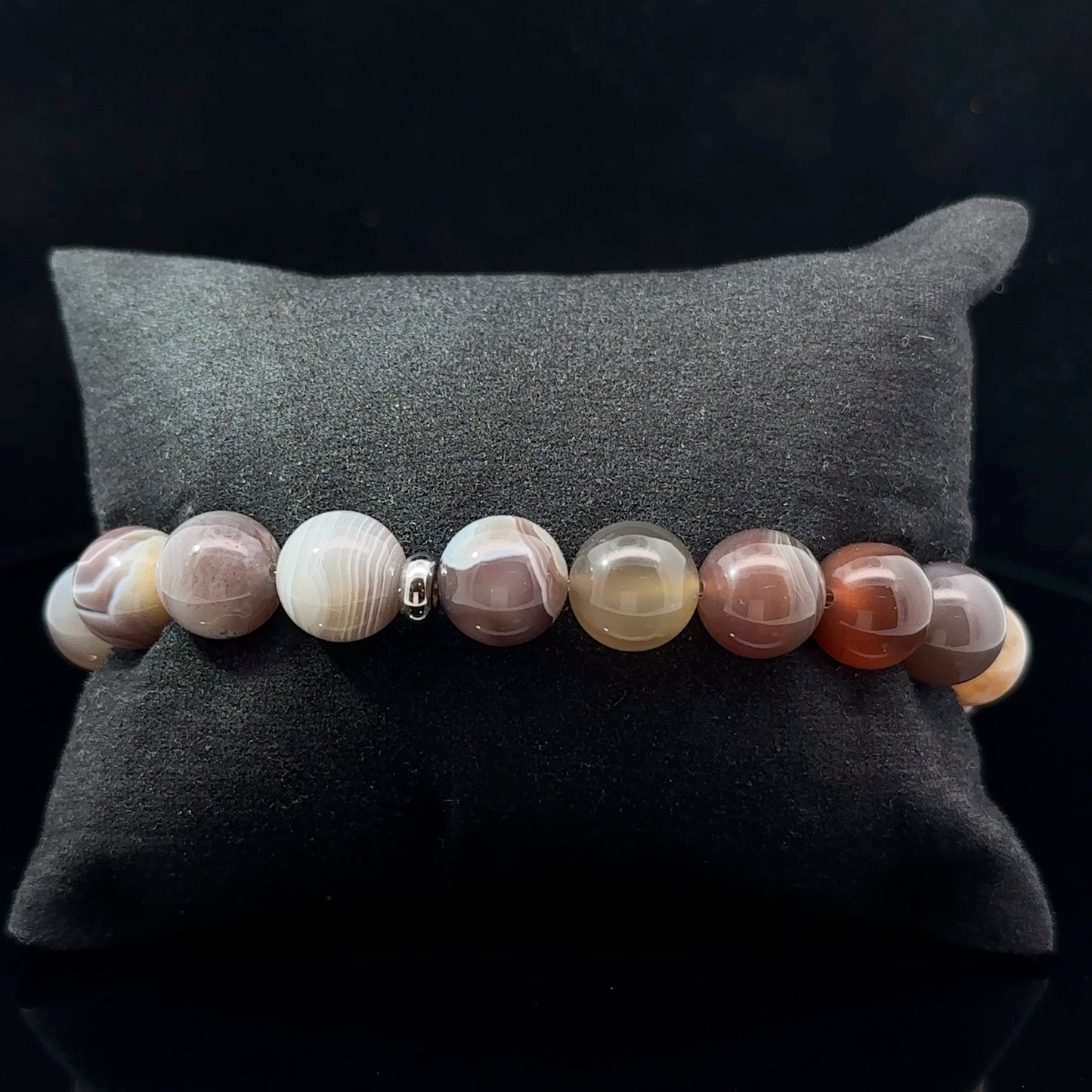 A multicolored agate bead bracelet with varying shades of gray, beige, and brown.