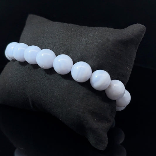 A bracelet with white and blue agate beads, displayed on a dark background, with a total of 29 beads.